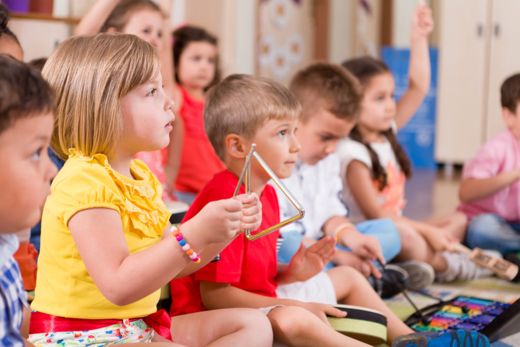 A photograph of young children during a music lesson